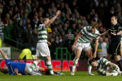 Lee McCulloch and Beram Kayal lie injured after a 50/50 challenge during an Old Firm match in 2011